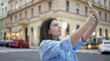 Genç ve güzel İspanyol kadın Viyana sokaklarında akıllı telefonuyla kayıt yapıyor.