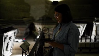 Genç ve güzel İspanyol kadın Viyana 'daki Imperial Crypt' de broşür okuyarak lahiti ziyaret ediyor.