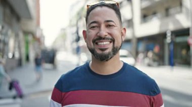 Young latin man smiling confident standing at street