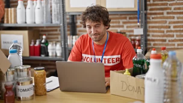 Νεαρός Ισπανός Εθελοντής Φορητό Υπολογιστή Που Δουλεύει Φιλανθρωπικό Κέντρο — Αρχείο Βίντεο