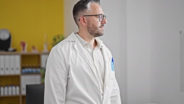 Grauhaariger Arzt Lächelt Zuversichtlich Mit Stethoskop Der Klinik — Stockvideo