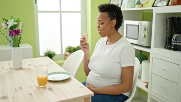 年轻的孕妇坐在饭厅的桌子上吃早餐 — 图库视频影像