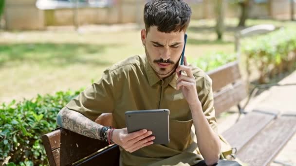 Joven Turista Hispano Usando Touchpad Hablando Smartphone Park — Vídeos de Stock