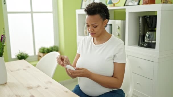 年轻的孕妇坐在饭厅的桌子上测量糖分 — 图库视频影像