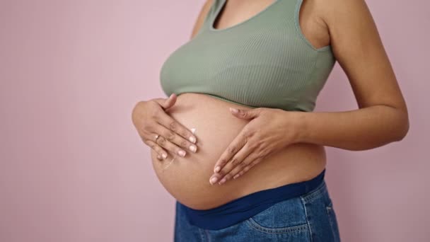 Jonge Zwangere Vrouw Aanbrengen Crème Buik Geïsoleerde Roze Achtergrond — Stockvideo