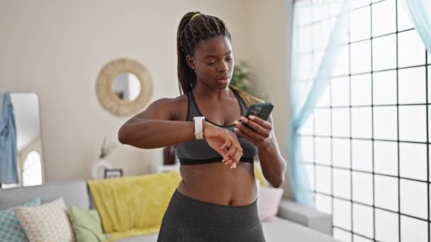 Mujer Afroamericana Usando Ropa Deportiva Usando Smartphone Reloj Casa — Vídeo de stock