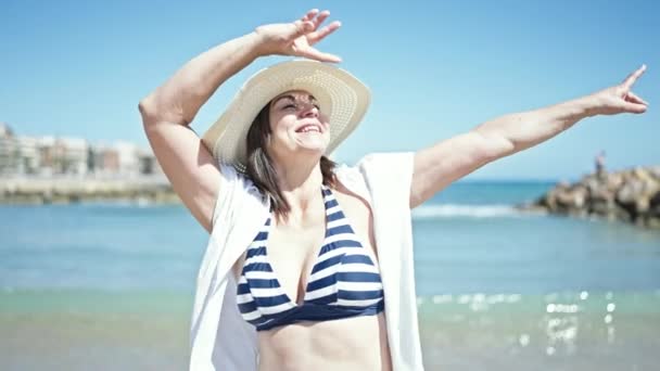 中年惊慌失措的女游客张开双臂站在海滩上 — 图库视频影像