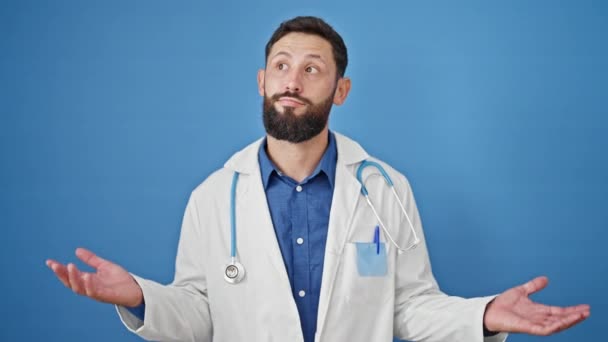 Ung Latinamerikansk Man Läkare Står Aningslös Över Isolerad Blå Bakgrund — Stockvideo