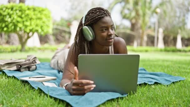 Studente Donna Afroamericana Che Utilizza Laptop Cuffie Sdraiato Sul Pavimento — Video Stock