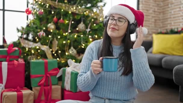 Mujer Hispana Joven Escuchando Música Con Auriculares Sombrero Navidad Casa — Vídeos de Stock