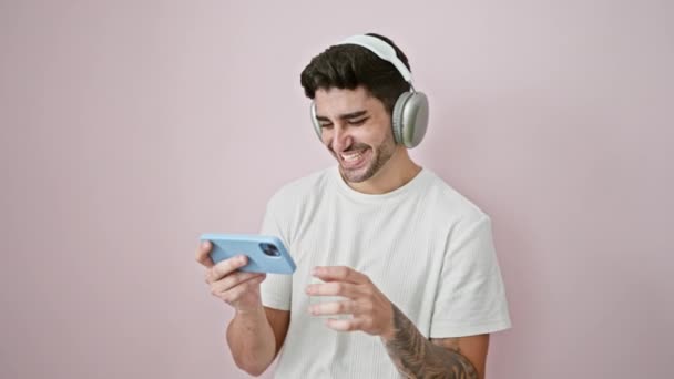 Joven Hombre Hispano Viendo Video Smartphone Sonriendo Sobre Fondo Rosa — Vídeos de Stock