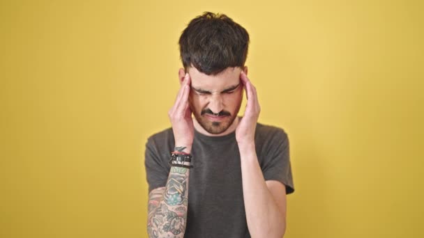 Mladý Hispánec Muž Trpí Bolestí Hlavy Přes Izolované Žluté Pozadí — Stock video