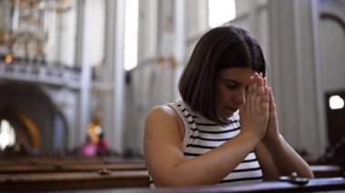 Viyana 'daki Augustinian Kilisesi' nde kilise bankında dua eden güzel İspanyol bir kadın.