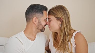 Kadın ve erkek yatak odasında birbirlerine sarılıp öpüşüyorlar.