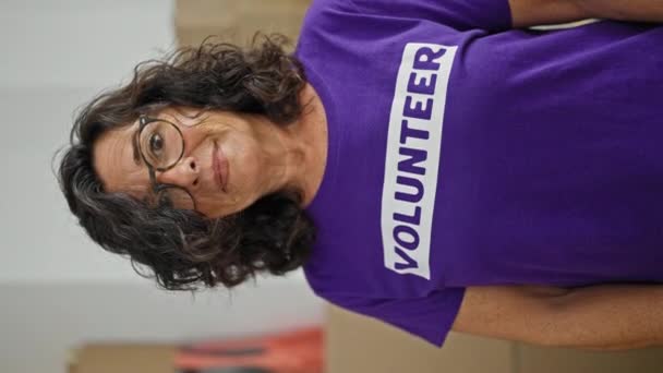 Mujer Hispana Mediana Edad Voluntaria Sonriendo Confiada Pie Centro Caridad — Vídeos de Stock