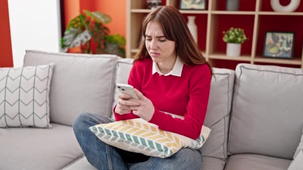 Mujer Hispana Joven Usando Teléfono Inteligente Sentado Sofá Buscando Molesto — Vídeos de Stock