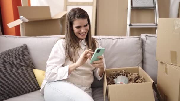 Young Beautiful Hispanic Woman Smiling Confident Using Smartphone New Home — Stockvideo