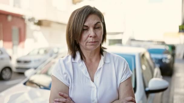 Middelbare Leeftijd Spaanse Vrouw Staat Met Gekruiste Armen Voor Auto — Stockvideo