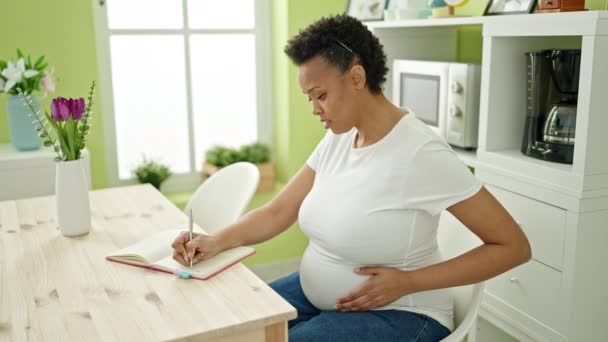 Mujer Embarazada Joven Escribiendo Cuaderno Sintiendo Patada Bebé Comedor — Vídeos de Stock