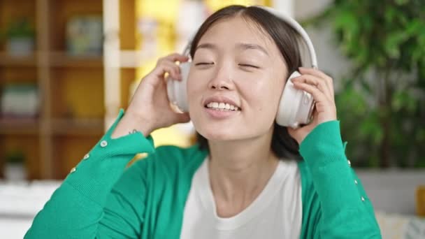 Young Chinese Woman Listening Music Sitting Sofa Home — Stock video