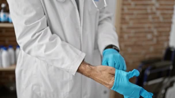 若いヒスパニック男性医師が診療所で手袋を着用 — ストック動画