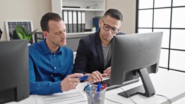 两名男工在办公室拿着电脑和信用卡购物 — 图库视频影像