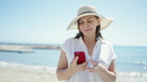 中年时 他惊慌失措的女游客面带微笑 自信地用智能手机在海滩上自杀 — 图库视频影像