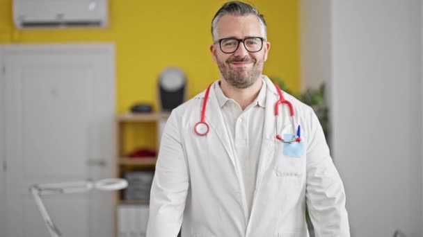Grauhaariger Arzt Lächelt Bei Herzensgeste Mit Händen Der Klinik — Stockvideo