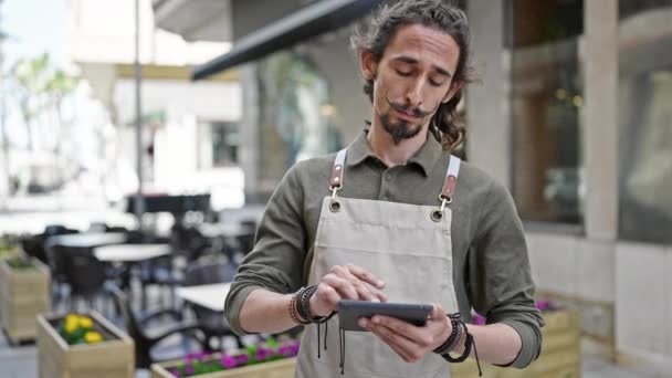 Giovane Uomo Ispanico Cameriere Utilizzando Touchpad Con Faccia Seria Sulla — Video Stock