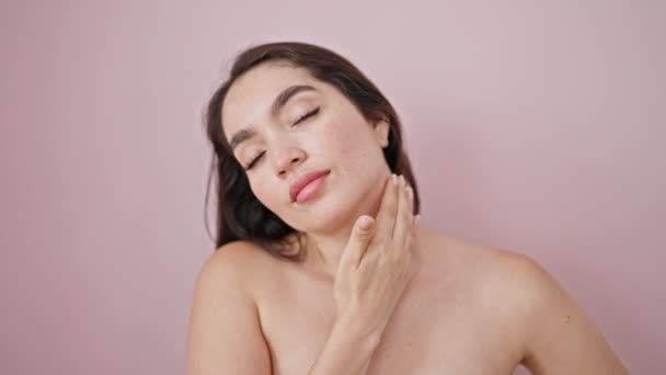 孤立したピンクの背景に首をマッサージする若い美しいヒスパニックの女性 — ストック動画