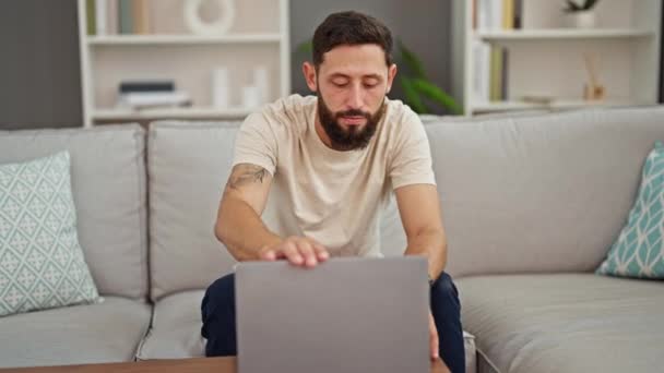 Jovem Hispânico Homem Fechando Laptop Sentado Sofá Com Braços Cruzados — Vídeo de Stock