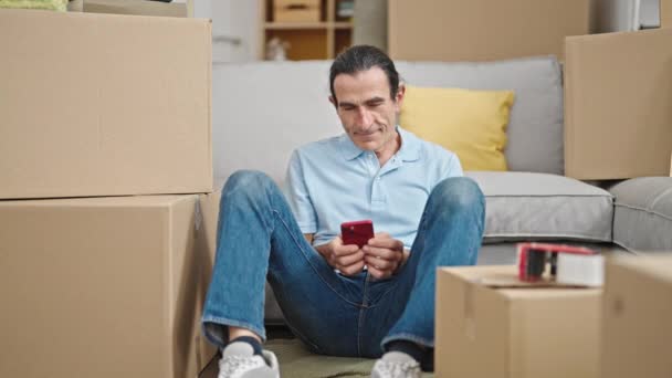 Homem Meia Idade Usando Smartphone Sentado Chão Nova Casa — Vídeo de Stock