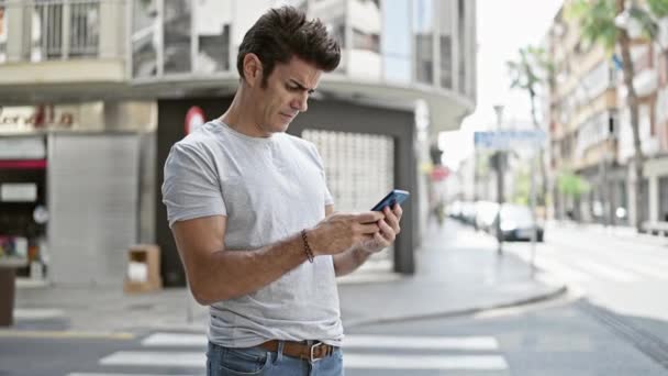 Jonge Spaanse Man Met Behulp Van Smartphone Vieren Straat — Stockvideo