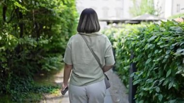 Genç ve güzel İspanyol kadın Viyana 'daki parkta yürüyor.