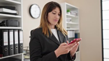 Young blonde woman business worker talking on smartphone working at office