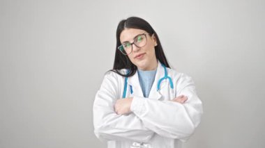 Genç İspanyol doktor, kendine güvenen gülümseyen kollarını kavuşturup izole beyaz arka planda hareketler yapıyor.