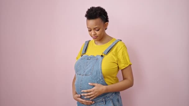 Mujer Embarazada Joven Sonriendo Confiado Haciendo Gesto Fuerte Sobre Fondo — Vídeo de stock