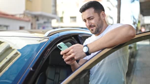 Young Hispanic Man Using Smartphone Leaning Car Street — Wideo stockowe