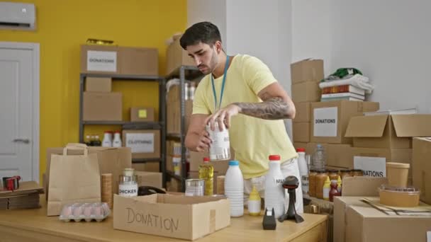 Junger Hispanischer Mann Legt Charity Center Freiwillig Produkte Auf Spendenkarton — Stockvideo