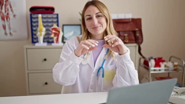 Joven Hermosa Mujer Hispana Doctora Sonriendo Haciendo Gesto Corazón Con — Vídeos de Stock