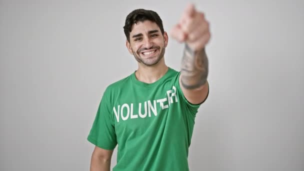 孤立した白い背景の上にカメラを指す若いヒスパニック系男性ボランティア — ストック動画