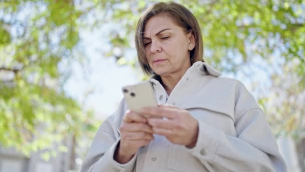 Medelålders Latinamerikansk Kvinna Använder Smartphone Parken — Stockvideo