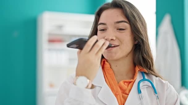 Joven Hermosa Mujer Hispana Médico Enviando Mensaje Voz Sonriendo Clínica — Vídeos de Stock