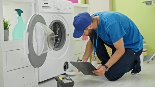 Νεαρός Ισπανός Τεχνικός Επισκευάζει Πλυντήριο Διαβάζοντας Οδηγίες Στο Πλυσταριό — Αρχείο Βίντεο