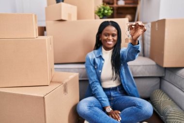 African american woman smiling confident holding key at new home