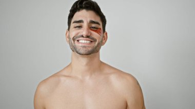 Genç İspanyol adam üstsüz duruyor ve beyaz arka plana çuval gibi göz bandı takıyor.