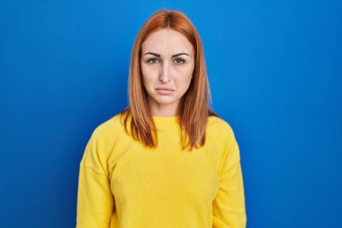 Young woman standing over blue background depressed and worry for distress, crying angry and afraid. sad expression. 