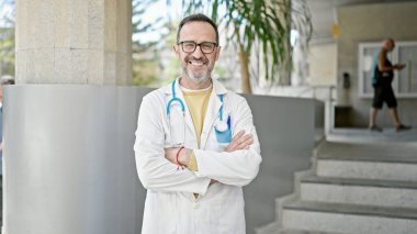 Hastanede kendine gülen orta yaşlı bir doktor.