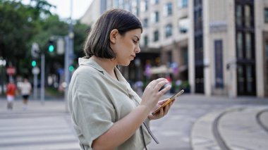 Kafeteryada akıllı telefon kullanan güzel bir İspanyol kadın.