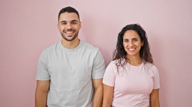 Kadın ve erkek, pembe arka planda birbirlerine güvenerek sırıtıyorlar.